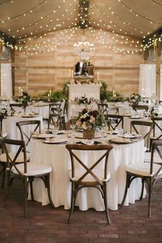 the tables are set with white tablecloths and chairs