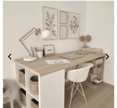 a desk with two chairs and pictures on the wall above it, next to a white chair