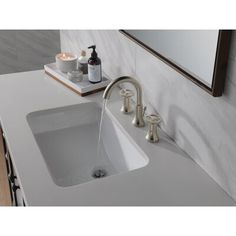 a bathroom sink with two faucets and soap dispensers on the counter