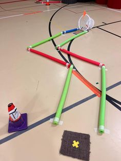 an indoor basketball court with several different colored sticks on the floor