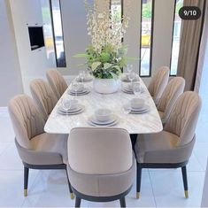 a dining room table with chairs and plates on it