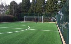 a man standing on top of a lush green field next to a soccer ball goal