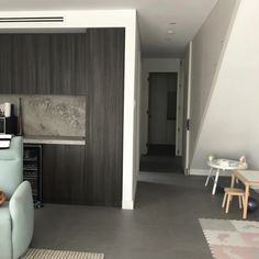 a living room filled with furniture next to a wall mounted flat screen tv on top of a wooden shelf