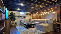 a living room filled with furniture and lots of lights hanging from the ceiling above it