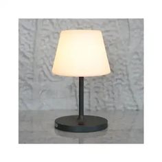 a lamp that is sitting on top of a table with a white light in front of it