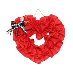 a red heart shaped wreath hanging on a wall with a black and white checkered bow