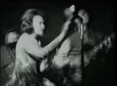 black and white photograph of two women singing into microphones