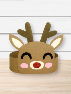 a cardboard reindeer head sitting on top of a wooden table