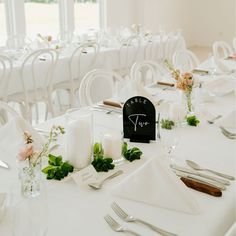 the table is set with white linens and silverware