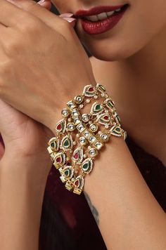 Express your love for pearls and florals with this chic bracelet. A timeless kundan bracelet set on a silver alloy base and embellished with a beautiful assembly of shell pearls, set on a 22k gold plated floral design. Bracelet - Adjustable Style Tip - When it comes to getting a classic look, nothing can be better than pearls and kundan. This bracelet is fit for a woman who is fiercely independent yet rooted in traditional and cultural heritage, carving her own style with classic and timeless fa Luxury Kundan Chandbalis In Fusion Style, Luxury Gold Kundan Bracelets, Elegant Kundan Jeweled Bracelets, Festive Jeweled Kundan Bracelets, Bollywood Style Hand-set Bracelets For Reception, Bollywood Style Hand Set Bracelets For Reception, Bollywood Style Bracelets For Reception And Festivals, Kundan Jeweled Bracelets For Celebration, Kundan Pearl Bracelet Gift