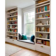 a window seat in front of a book shelf filled with books