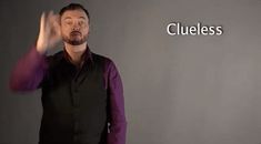 a man standing in front of a sign with the word clueless written on it