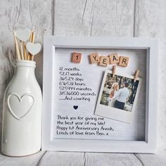 a photo frame with the words i love you in scrabbles next to a vase