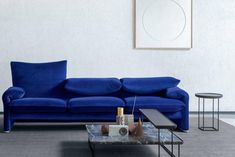 a blue couch sitting in a living room next to a coffee table and end tables