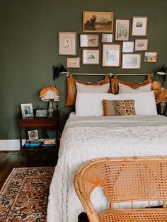 a wicker bed in a bedroom with pictures on the wall above it and an antique chair