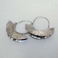 "Sterling silver forged earrings, have a semicircle shape and resemble a ruffle. They are made with the fold forming technique, . The fold forming technique allows small three-dimensional sculptures by the combined use of folding, fire, and hammer work. The processing of these earrings requires numerous steps of hammer beating in order to obtain the three-dimensional structure but the end result always leaves me enchanted. Lightweight, with a simple and clean design, they are suitable to be worn Silversmithing Jewelry, Oxidized Silver Earrings, Jewelry Design Inspiration, Minerals And Gemstones, Framed Painting, Brass Jewelry, Copper Earrings, Sterling Silver Hoops, Contemporary Jewelry