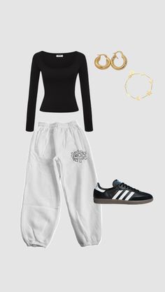 a black top, white pants and gold hoop earrings are featured in this fashion photo