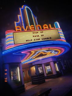 the marquee for avenue theater is lit up with neon lights at night time