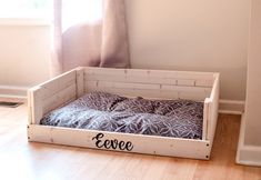 a dog bed made out of pallets with the word eevee written on it