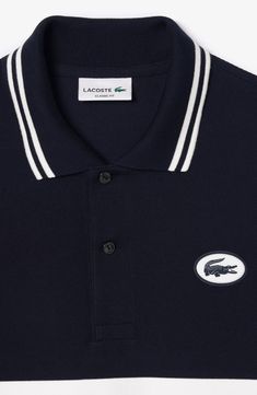 Sporty and French-inspired, this classic-fit polo features placed stripes, tipped edges and a silicone logo at the chest for iconic Lacoste style. 28" length Button half placket Spread collar Short sleeves 100% cotton Hand wash, line dry Imported Classic Polo Shirt With Contrast Stripes, Classic Navy Polo Shirt With Ribbed Collar, Classic Polo Shirt With Signature Stripes, Classic Collared Polo Shirt With Signature Stripes, Classic Striped Polo Shirt With Collared Neckline, Classic Navy Polo Shirt With Contrast Collar, Classic Striped Polo Shirt, Classic Three-stripes Polo Shirt, Classic Three Stripes Polo Shirt