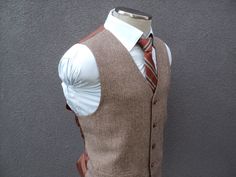 Elegant Brown Vest With Notch Lapel, Elegant Brown Notch Lapel Vest, Brown Business Vest With Notch Lapel, Brown Notch Lapel Vest For Business, Formal Brown Sleeveless Outerwear, Brown Sleeveless Formal Outerwear, Tailored Brown Vest With Notch Lapel, Brown Three-piece Suit For Semi-formal Events, Brown Three-piece Suit For Semi-formal Occasions