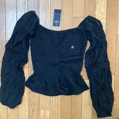 Hollister Long Sleeve Shirt With Scrunchie Material And Puffy Sleeves. Color: Black And Size: Xs. Never Worn And Still Has Tags Attached! Casual Black Fitted Blouse, Casual Fitted Ruched Tops, Casual Black Ruched Top, Hollister Long Sleeve Shirts, Hollister Long Sleeve, White Ruffle Top, Sheer Floral Top, Flare Long Sleeve, Grey Blouse