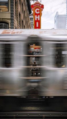 a blurry photo of a train passing by a building with a sign on it