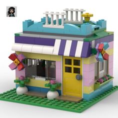 a toy house made out of legos on a white background with a photo of the front door and windows