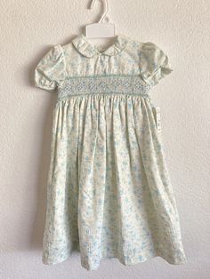 a white and blue dress hanging on a wall