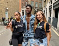 three people standing in the street posing for a photo