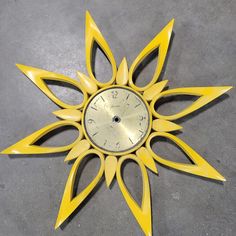 a yellow clock that is sitting on the ground with it's face in the shape of a star