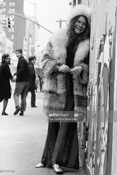 a woman leaning against a wall on the street