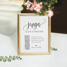 a sign that says genga guestbook on top of a table with flowers in the background