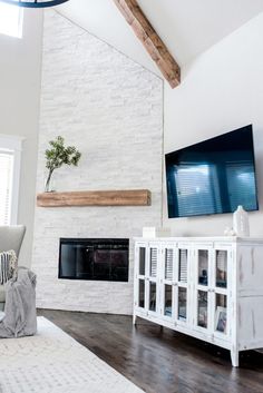 a living room with white brick fireplace and entertainment center