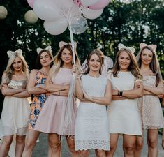 a group of women standing next to each other with balloons in the shape of hearts