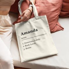 a person sitting on a bed with a bag in front of them that says amanda