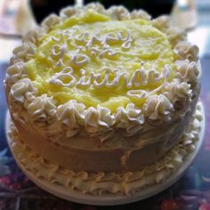 a close up of a cake with frosting on a glass tableclothed surface