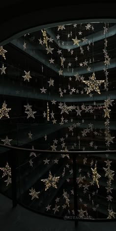 an artistic display with gold stars on the ceiling and in the middle is a spiral staircase