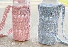 two crocheted water bottles sitting on the ground next to each other, one with a bottle in it