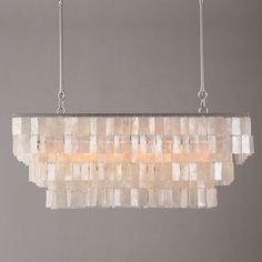 a rectangular chandelier made out of mother of pearl beads hanging from a chain