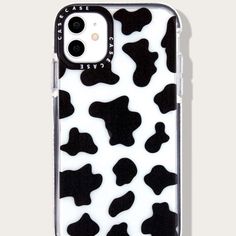 an iphone case with black and white cow print on it's back, sitting in front of a gray background