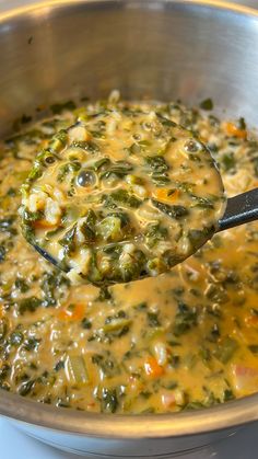 a ladle full of soup sitting on top of a stove