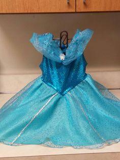 a blue princess dress sitting on top of a counter