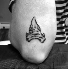 a woman's foot with a small hat tattoo on her left side calf area