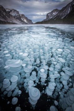 ice floes floating on top of a lake surrounded by mountains