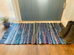 a pair of brown boots sitting on top of a blue rug next to a door