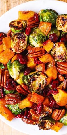 a white plate topped with brussel sprouts and sweet potatoes