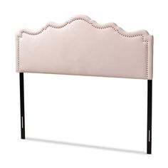 an upholstered headboard with black metal legs and pink leather trimmings