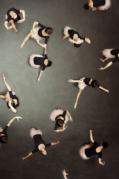 aerial view of dancers in black and white outfits with their arms spread out to the side