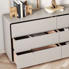 a grey dresser with drawers on top of it next to a lamp and bookshelf